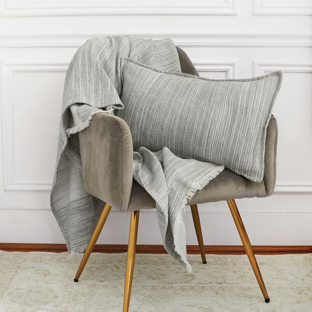 woven grey decorative pillow and throw on a chair