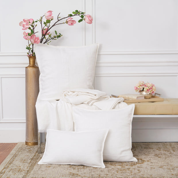 The Beacon White collection styled on a bench with pink flowers.