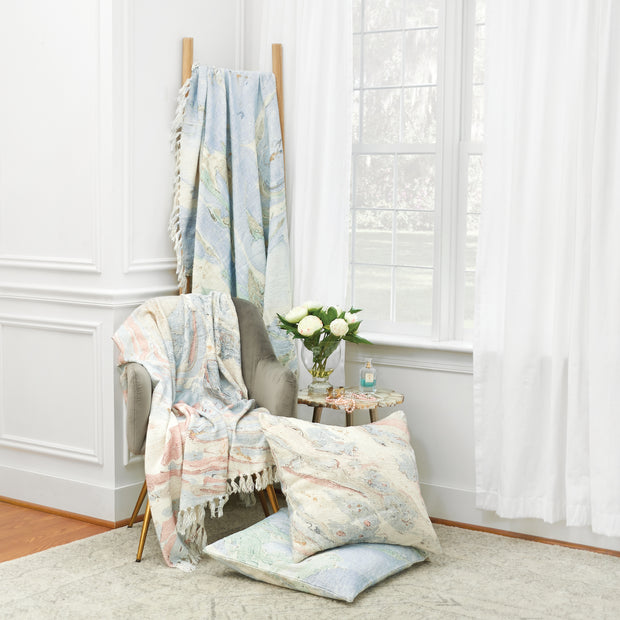 decorative pillow and throw with marble design on a chair
