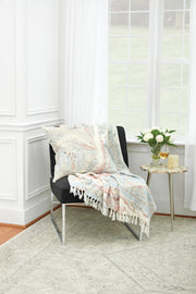 decorative pillow and throw with marble design on a chair