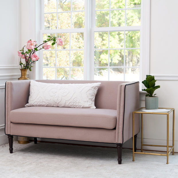 oblong white decorative pillow with a stonewashed cord embroidered design on a couch