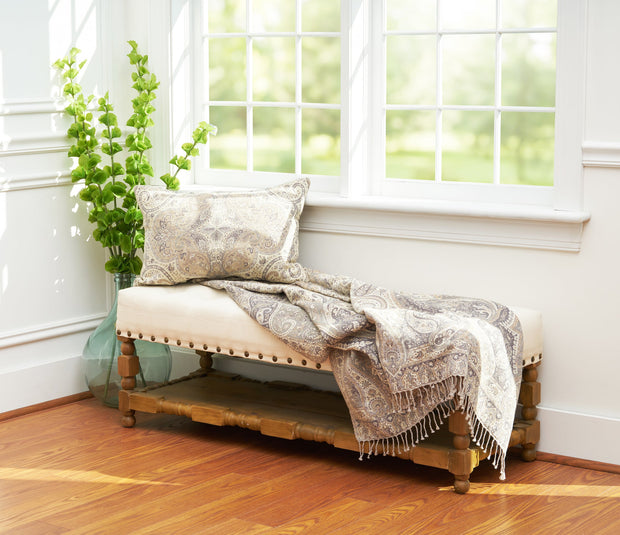 tan throw featuring a paisley pattern displayed on a bench and paired with a matching pillow