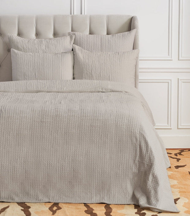 Pearl gray waffle weave coverlet.